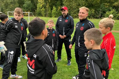 Jugendleiter Tim Planitzer (Dritter von rechts) und einer der Trainer, Mike Kranzusch (links daneben), instruieren hier gerade die Fußballer.