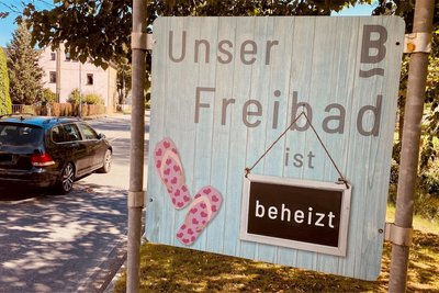 Das Burkhardtsdorfer Freibad wirbt mit einer hübschen Tafel um Besucher.