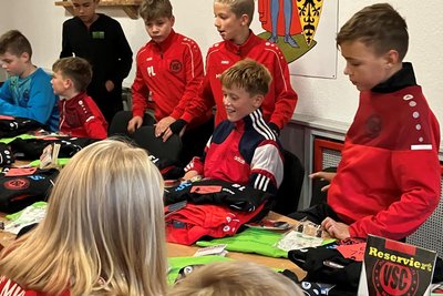 Die jungen Fußballer erhalten hier gerade neue Präsentationsanzüge.