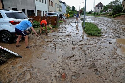 Kampf dem Schlamm: Nur zehn Minuten hatte es Anwohnern zufolge gedauert, bis sintflutartige Regenfälle am Samstagnachmittag den kleinen Dittrichbach an der Forststraße bei Meerane zum Überlaufen brachten. Schon kurz nach dem Unwetter begann das Reinemachen. 