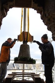 Blick aus dem Turm: Arbeiter nehmen eine Glocke entgegen.