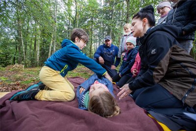 Stephanie Mothes, Vereinsmitglied der Freiwilligen Feuerwehr Jocketa, erklärte Grundlagen zur Ersten Hilfe. Hans legt Esther dabei behutsam in die stabile Seitenlage.