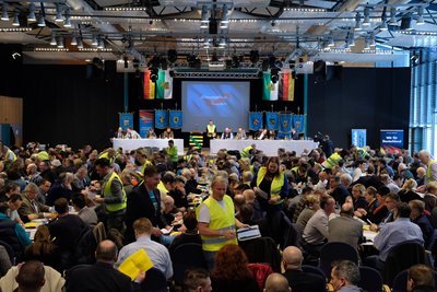 Wahlhelfer mit gelben Westen sammeln beim Landesparteitag der sächsischen AfD Stimmzettel ein.