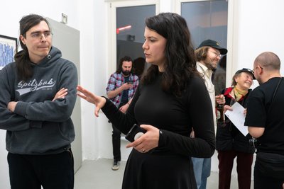 Kuratorin Alexandra Costea (Mitte) diskutiert mit Besuchern der Vernissage.