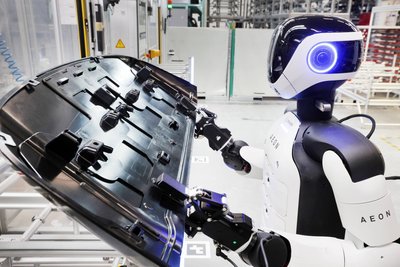 Hier schafft der Roboter Spritzgussteile für einen Mini Countryman heran und legt sie in eine Maschine, wo sie verklebt werden.