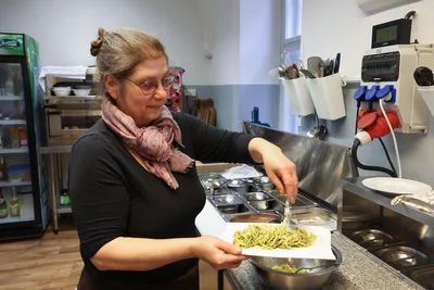 Küchenfee Yvonne Renner streut noch Parmesan auf die Pesto-Spaghetti.