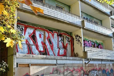 Vernagelte Fenster und Graffiti-Schriftzüge: die Fassade des Hochhauses von vorn.