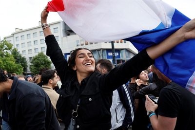 In Nantes schwenkt eine Frau die französische Flagge, als die ersten Hochrechnungen veröffentlicht werden und zeigen, dass die Rechtsnationalisten nur auf Platz drei landen.