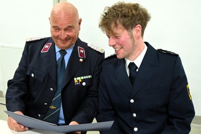 Andreas Schubert (links) zeigt Kreisbrandmeister Gerd Pürzel die Urkunde für die Alters- und Ehrenabteilung.