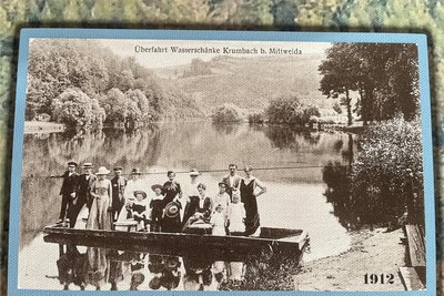 Im Vorraum zur Gaststätte wird an per Postkarten an verschiedene Epochen der Wasserschänke mit Fähre Anna erinnert, hier eine Hochzeitsgesellschaft von 1912.