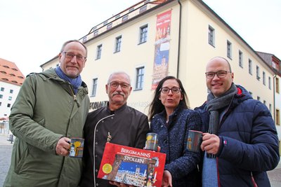 Bürgermeister Holger Reuter, Bäckermeister Oliver Härtig, Anja Fiedler, Leiterin des Amtes Kultur-Stadt-Marketing, und David Bojack, Leiter des Sachgebietes Events und Märkte (v.l.), präsentieren Bergmannsstollen und Glühweintassen zum Christmarkt.