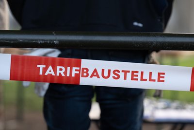 Ein Absperrband mit der Aufschrift „Tarifbaustelle“ hängt während eines Warnstreiks des Regionalverkehrs an der Zufahrt zu einem Betriebshof.