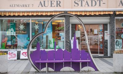 Eine Bank in Herzform - natürlich in Lila - steht auf dem Auer Altmarkt. 