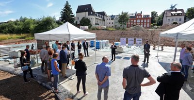 Lichtensteins Bürgermeister Thomas Nordheim (Foto Mitte hinten) spricht zur Grundsteinlegung für das auf dem Gelände der einstigen Bergfabrik im Stadtteil Callnberg zu errichtende Kita-Gebäude. Bauherr ist die Städtische Wohnungsgesellschaft. 