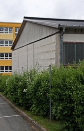 Es grünt so grün: Am Giebel der Turnhalle wächst eine Hecke und verdeckt die Tristesse.