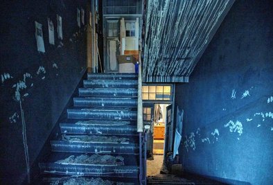 Im Treppenhaus des Stadthauses hat sich eine dicke Rußschicht auf alles gelegt. Handabdrücke an den Wänden zeugen vom einstigen Anstrich.