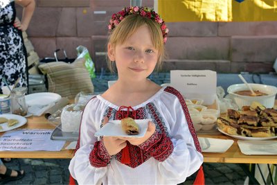 Auf einem vom Helferkreis Adorf organisierten "Markt der Kulturen" wurden internationale Speisen angeboten. Viktoria aus der Ukraine kostete gefüllte Hörnchen aus Syrien.