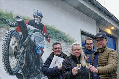 Vor einem Wandbild, das ihren Vater in Aktion zeigt, übergaben Yannic und Eric Cyffka ihre Spende sowie einige Sticker an Daniela Lieberwirth und Christian Frank (v. r.) vom Chemnitzer Lukas-Stern-Verein.