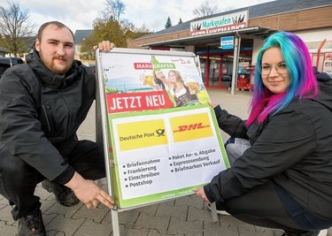 Im Getränkemarkt befindet sich demnächst eine Postagentur: Marktleiter Lukas Seerig und Mitarbeiterin Emily Elster (v. l.) bestücken einen Werbeaufsteller in Seiffen mit einem Hinweisplakat. 