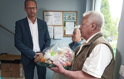 Tatjana und Leonid Lapin werden im Flur vom Geschäftsführer der Gebäudegesellschaft Limbach-Oberfrohna, Norbert Gruss, zum Einzug in ihre neue Wohnung mit einem Obstkorb begrüßt. 