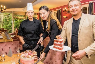 Köchin Jaroslava Fiedlerova, Hotelmanagerin Barbora Broumova und Generaldirektor Karol Balog beim Anschneiden der speziellen Torte im renovierten Wintergarten der Drei-Brüder-Höhe. 