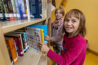 Sina (vorn) und Lilly haben am Donnerstag gleich mal Lesefutter geholt. Die Auswahl ist groß. Es gibt in der neuen Bibliothek rund 1000 Bücher.