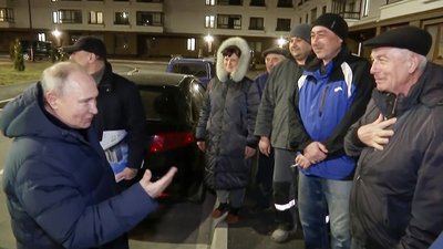 Auf diesem von einem russischen Fernsehsender am 19.03.2023 veröffentlichten Videostandbild spricht Wladimir Putin (vorne,l), Präsident von Russland, während seines Besuchs in Mariupol mit Anwohnern.