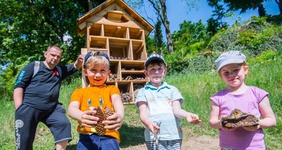 Kinder aus der Kita Hofgarten - hier v. r. Alina Müller, Valentin Rataj, Jonas Brecher - haben das von Ben Roscher (l.) gebaute und im Schlossgarten in Schwarzenberg aufgestellte Insektenhotel noch bestückt. 