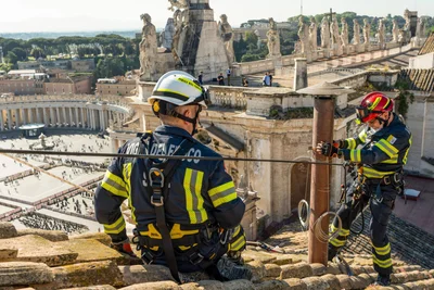 Feuerwehrleute installieren einen provisorischen Schornstein auf dem Dach der Sixtinischen Kapelle im Vatikan, der Rauchzeichen - schwarz oder weiß - abgeben wird und anzeigt, ob ein neuer Papst gewählt wurde.