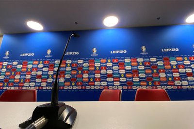 Vor einer Wand aus mehr als 300 Sponsorenlogos stellen sich die Trainer den Medienfragen.