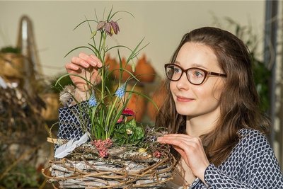Fertig: Mit Leim und Draht verbindet Sophie Pfeiffer den bepflanzten Tontopf mit dem Holzkranz. Verfeinert mit Clematisranken, Birkenzweigen, Pfeffer, Federn und Eiern ist der Osterschmuck perfekt.