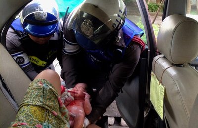 Das Bild der Polizei Bangkok vom Juni zeigt einen speziell geschulten Polizisten, der bei der Geburt eines Babys in einem Taxi in Thailand hilft. Die andauernden Staus in Thailands Hauptstadt bescheren manchen schwangeren Frauen eine Geburt im Auto auf dem Weg ins Krankenhaus. Eine speziell geschulte Polizeieinheit hat bereits mehr als 100 Babys am Straßenrand zur Welt gebracht. 