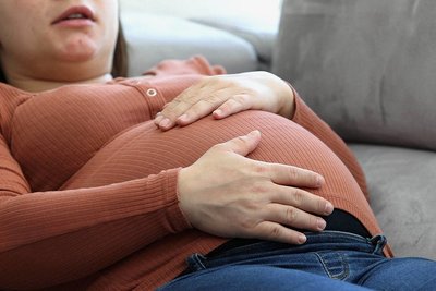 Eine schwangere Frau, die sich hingelegt hat. Doch macht Schwangerschaft wirklich müde? 