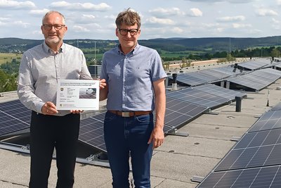 Oberbürgermeister Jens Scharff und Elektrotechnikermeister Thorsten Wirth besichtigen die neue PV-Anlage.