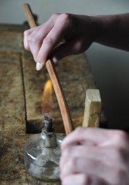 Bitte nicht stören: Die Flamme des Spiritusbrenners soll das Holz für den Instrumenten-Bogen biegsam machen, doch gerät das Feuer zu nah oder zu lang an den dünnen Stab, ist er nicht mehr zu gebrauchen.