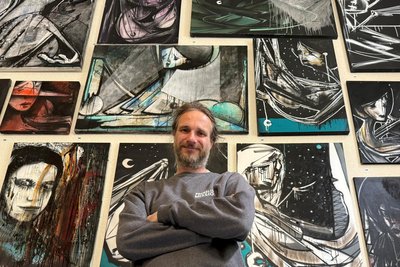Guido Günther, Geschäftsführer der Chemnitzer RebelArt GmbH mit Ableger in Etzdorf vor einer Wand mit seinen Arbeiten.