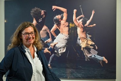 Designerin Kathi Halama hat die Ausstellung kuratiert. Sie steht vor ihrem Lieblingsfoto von Dieter Wuschanski. Es entstand beim Tanzfestival in Chemnitz. Zu sehen ist die Gruppe von Hervé Koubi.