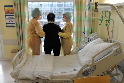 Die Physiotherapeutinnen Jasmin Ihle (l.) und Sophia Krasel helfen einer Patientin auf der Coronastation für normale Verläufe auf die Beine.