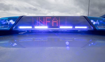 Ein Blaulicht und eine LED-Anzeige leuchten auf dem Dach eines Polizeifahrzeugs.
