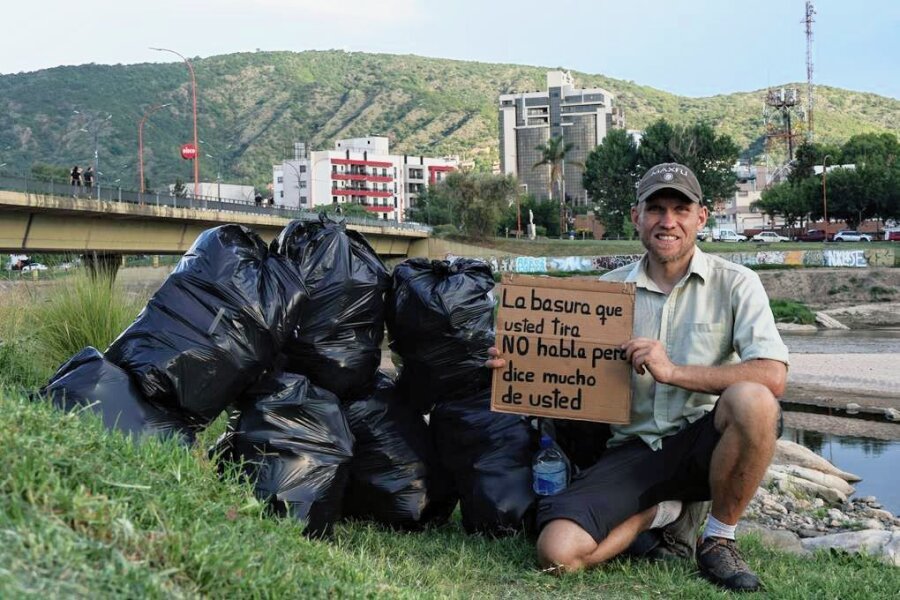 45-Jähriger aus dem Erzgebirge räumt in Argentinien den Müll weg - Sebastian Engel mit einem Pappschild, das auf die Müllproblematik im argentinischen Villa Carlos Paz aufmerksam machen soll. Der Text: "Der Müll, den Sie wegwerfen, spricht nicht, aber er sagt viel über Sie aus." 