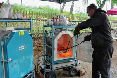Nachdem die Keramik im Ofen bei rund 1000 Grad Celsius gebrannt wurde, holt Ingo Chinow sie mit langen Zangen vorsichtig heraus. 