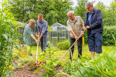 Brigitte Mothes probiert die von den Rotariern mitgebrachte Harke gleich aus: Mit Rotary-Präsident Michael Hummel, Peter Weiß und Matthias Seidel (von links).