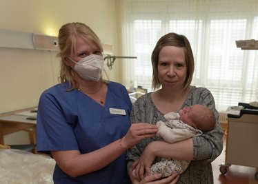 Sandra Löhrke mit ihrer kleinen Tochter Marie, die an Neujahr im Auer Helios Klinikum geboren worden ist und Assistenzärztin Annelies Goldhahn (li.) 