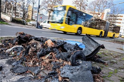 Eine geschmolzene Mülltonne liegt nach Krawallen in der Silvesternacht auf einem Bürgersteig im Berliner Bezirk Neukölln. 