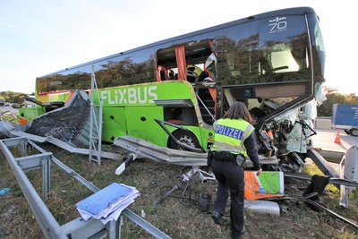 Polizisten arbeiten an einer Unfallstelle, an der ein Reisebus des Fernreiseunternehmens Flixbus auf der Autobahn 5 (A5) an der Abfahrt zur Tank- und Rastanlage Bruchsal in einen Fahrbahnteiler geprallt war.