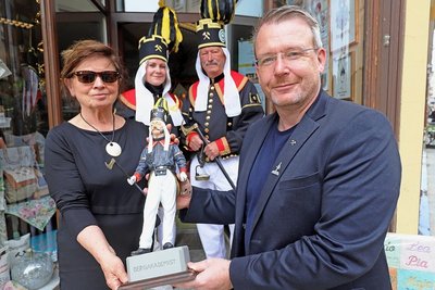 Iris Thiele (l.) und Sven Krüger (r.) präsentieren Bergakademisten in drei Größen: ganz klein am Revers des OB, klein und aus Holz in ihren Händen und in Fleisch und Blut mit zwei Mitgliedern der Historischen Freiberger Berg- und Hüttenknappschaft.