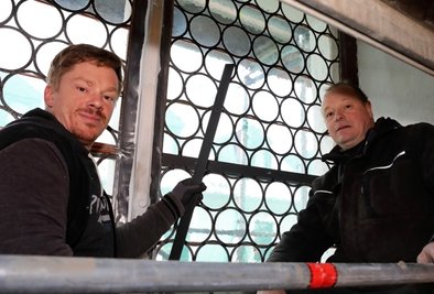 Reik Buhlig (r.) und David Zimmermann beim Einbau der sanierten, historischen Glasfenster in St. Georgen. 