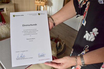Stolz zeigt die Friedensrichterin die Urkunde, die sie jetzt für ihr Ehrenamt in Dresden bekommen hat.