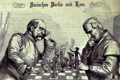 Zeitgenössische karikaturistische Darstellung des Kulturkampfs zwischen römisch-katholischer Kirche und deutscher Reichsregierung im Journal "Kladderadatsch" - Papst Pius IX.: "Der letzte Zug war mir allerdings unangenehm, aber die Partie ist deshalb noch nicht verloren. Ich habe noch einen sehr schönen Zug in petto." - Otto von Bismarck: "Das wird auch der letzte sein, und dann sind Sie in wenigen Zügen matt - wenigstens für Deutschland." 