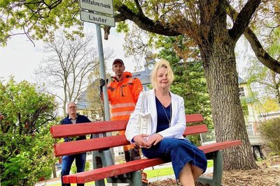 In Lauter-Bernsbach stehen zwei Mitfahrerbänke. Ideengeber waren Frank Harmsen (h. l.) und Ute Knauft. Bauhofmitarbeiter Kai Leßmüller stellte an der Bank ein Schild auf.